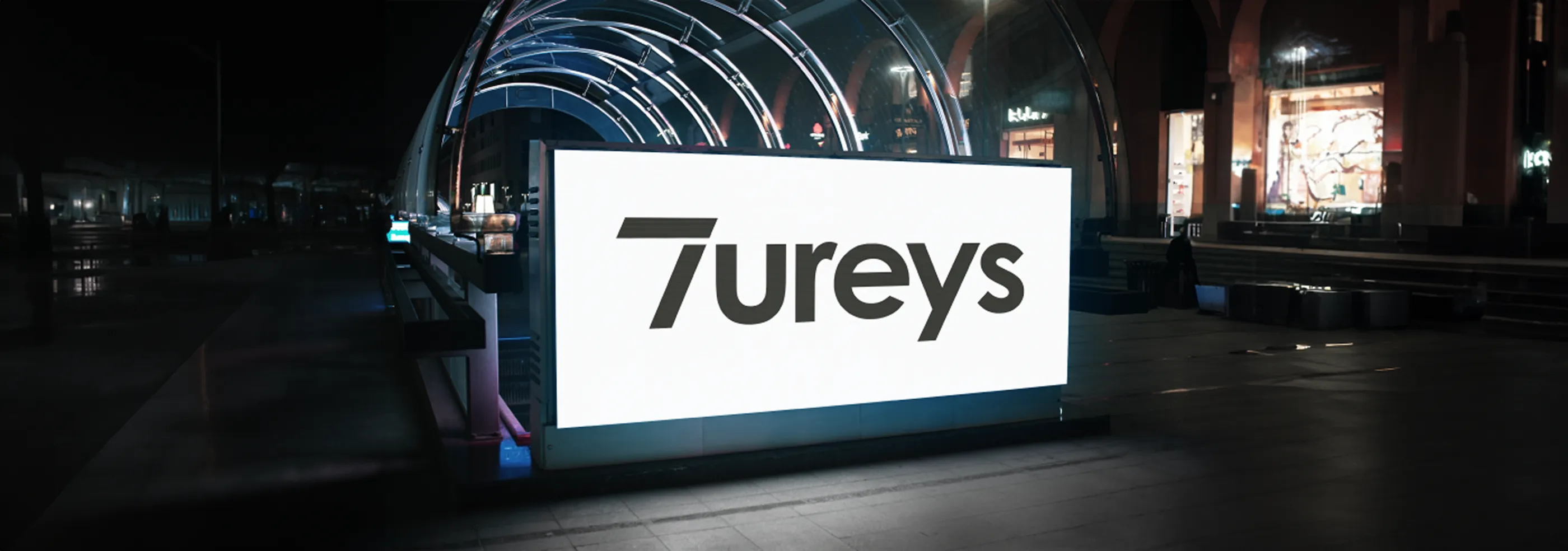 Illuminated Tureys sign on a city street at night